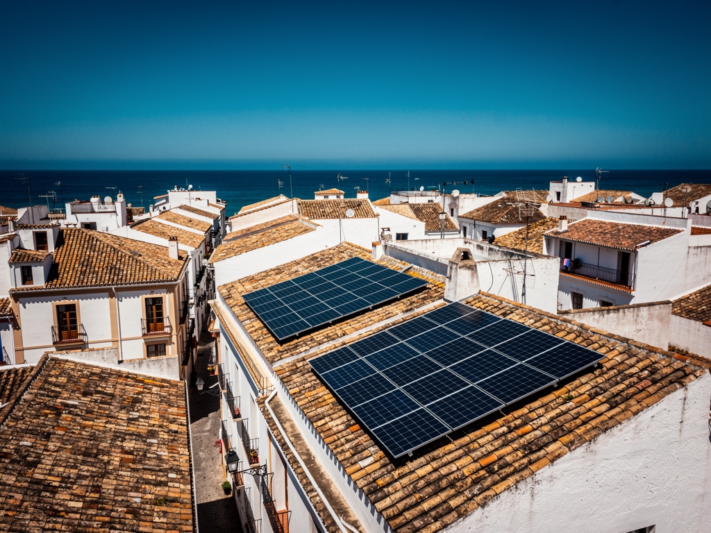 Tejados de Málaga con paneles solares fotovoltaicos bajo cielo despejado